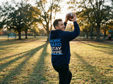 Person holding a football in a park with 'Work Hard Stay Hype' hoodie